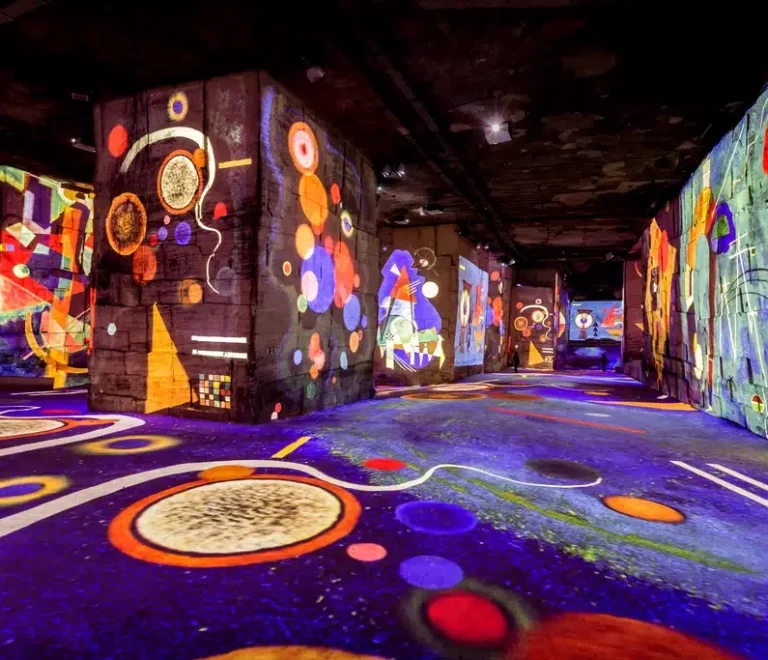 Exposition immersive avec projections colorées sur murs.