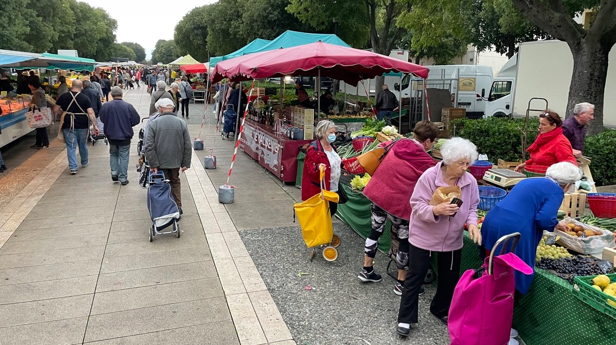 Marché local avec stands de fruits et légumes.