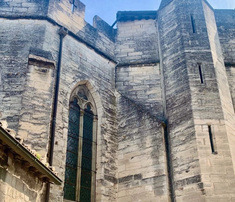 Mur médiéval en pierre avec grande fenêtre.