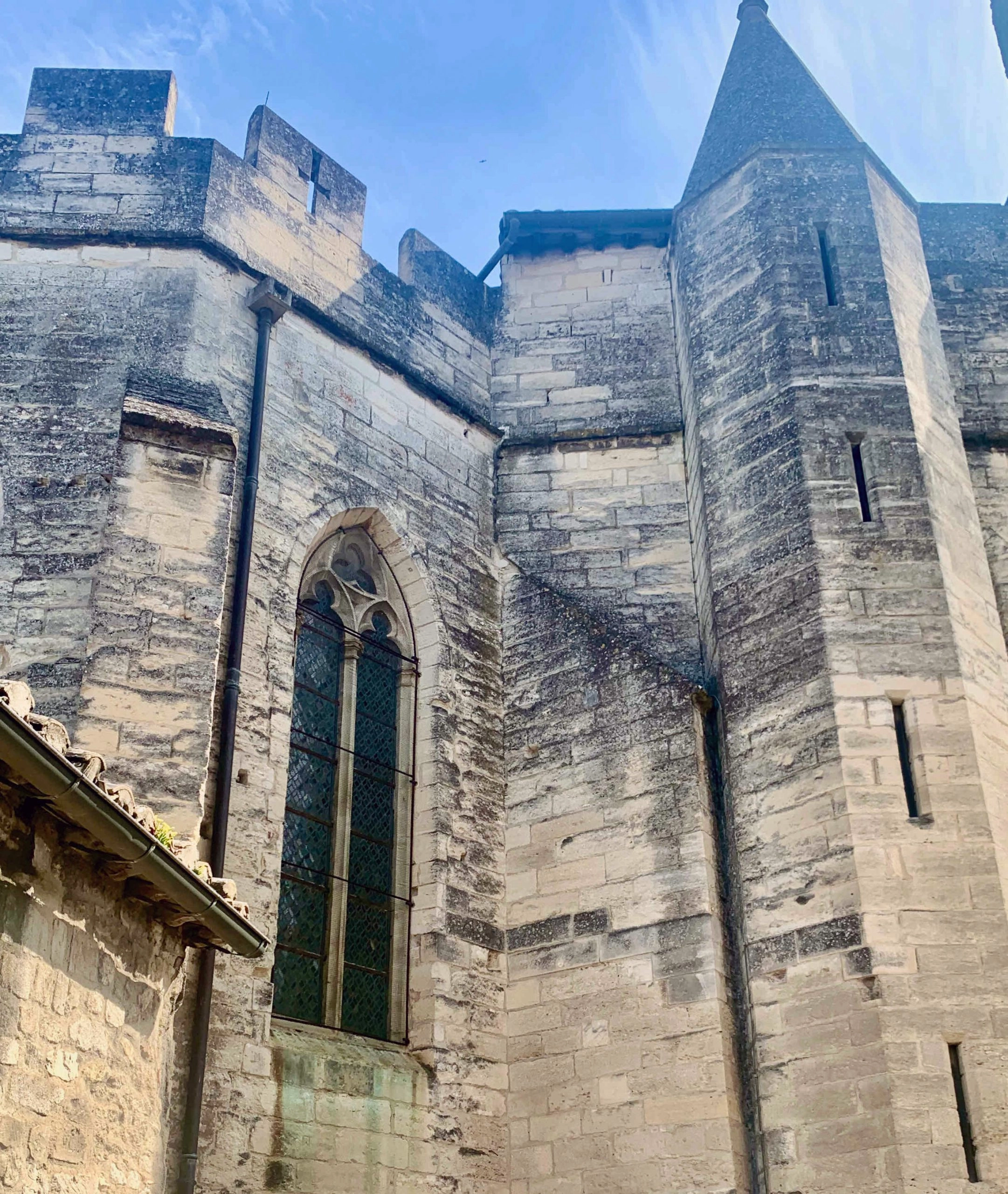 Mur médiéval en pierre avec grande fenêtre.